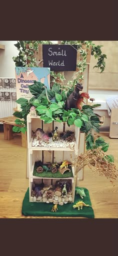 a shelf filled with lots of different types of toys and plants on top of a wooden floor