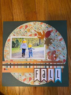 a scrapbook page with an image of two children walking in the fall leaves on it