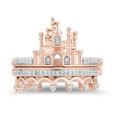 a rose gold and diamond ring with a castle in the middle, surrounded by smaller white diamonds