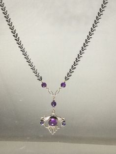 This "Eye of Amethyst" amulet is a power object, light and easy to wear with adjustable length. Pendant size: 1" H x 1 3/16" W. Drop length of pendant: 1 3/4". Longest length of adjustable Sterling Silver chain 19.75". One of a Kind and signed. Amethyst is believed to have healing and protective powers. Known to bring balance into one's life, Amethyst as an amulet is for those seeking inner peace, spiritual growth, and protection from negative energies. Like a crisp, dark winter sky, Iolite, in shifting shades of violet-blue facets carries the spirit of the journey, of dreams and intuition, of exploration and illumination. The Iolite is faceted and set on each side of Amethyst in perfect balance and harmony. The iconic look of the stainless steel chevron chain will twist and turn which add Amethyst Pendant Jewelry With Adjustable Chain, Purple Gemstone Amulet Necklace, Purple Amethyst Amulet Necklaces, Purple Amethyst Amulet Necklace, Purple Amulet Necklaces As Gifts, Spiritual Amethyst Pendant Jewelry, Purple Amethyst Amulet Jewelry, Purple Spiritual Necklace With Large Pendant, Spiritual Purple Necklace With Large Pendant