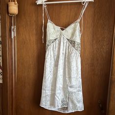 Elegant White Slip Dress With Delicate Lace Trim. Features Adjustable Straps And A Flattering Fit. Summer Lace Slip Dress For Loungewear, Sleeveless Summer Mini Dress For Wedding Night, Sleeveless Mini Dress For Wedding Night In Summer, Chic Sleepwear For Wedding Night In Summer, Chic Summer Sleepwear For Wedding Night, Chic Summer Wedding Night Sleepwear, Silk Summer Party Sleepwear, V-neck Mini Dress For Wedding Night In Spring, Summer Loungewear Mini Dress With Lace Trim