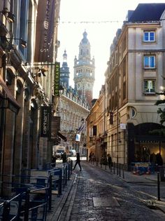 a city street with buildings and a clock tower in the background