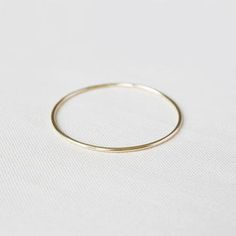 The classic Yearly Co. 14k bangle in a heavier weight and slightly thicker width. This bangle is made of solid 14k gold and measures 1.6mm thick or 14 gauge. Available in yellow, white and rose gold. Everyday Timeless Stackable Bangle, Simple 14k Yellow Gold Bracelets, Minimalist 14k Gold Bangle Jewelry, Gold Hoop Bangle In Minimalist Style, Minimalist Gold Hoop Bangle, Minimalist Yellow Gold Bracelets For Layering, Minimalist 14k Gold-filled Round Bracelets, Minimalist Stackable Round Band Bracelets, Minimalist 14k Gold Filled Round Bracelet