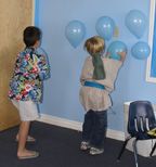 two young boys playing with balloons in a room