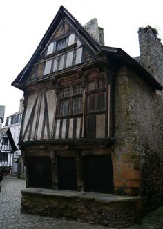 an old wooden and stone building on a cobblestone street