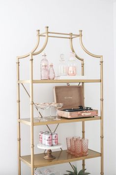 a shelf filled with glasses and bottles on top of it