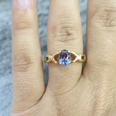 An oval cut violet tanzanite is the focal point for this lovely ring. The beautiful tanzanite is set in 14k yellow gold with an accenting braided infinity criss-cross band. Metal: 14K Yellow Gold Tanzanite: 7 x 5 MM Size: 8.5 If you have any questions about this product or if we can help you with any of our other products please contact us. Each piece of our jewelry has been identified by our Graduate Diamond Grader certified by the Gemological Institute of America (GIA). For more information ab Infinity Band Ring, Infinity Band, Band Metal, Lovely Ring, Oval Cut, Band Ring, Criss Cross, Sapphire Ring, Focal Point