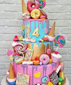 a multi layer cake decorated with candy, candies and doughnuts on top