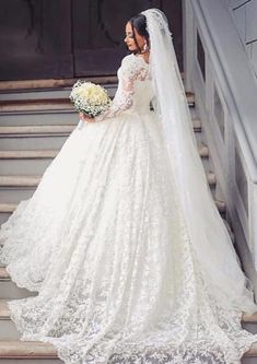 a woman in a wedding dress standing on some steps