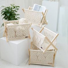 three woven baskets with wooden handles and two magazine holders on top of each other, sitting next to a potted plant