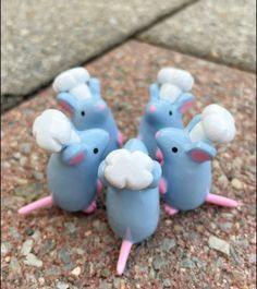 small blue and pink toy mice sitting on the ground with their heads turned to look like they are eating something