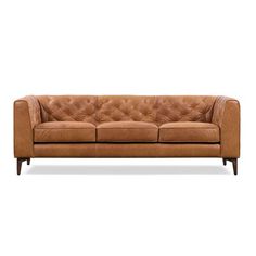 a tan leather couch with wooden legs and buttons on the armrests, against a white background