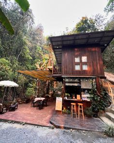 a small wooden house sitting in the middle of a forest