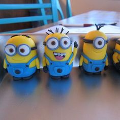 five minion toys are lined up on a table