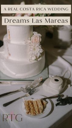 a white wedding cake sitting on top of a table next to a knife and fork