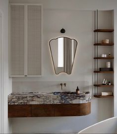 a bathroom with a sink, mirror and shelving