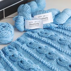 two skeins of blue yarn next to each other on a white counter top