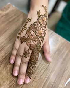 a woman's hand with henna tattoos on it