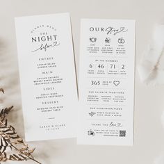 two white wedding programs on top of a table next to some flowers and greenery