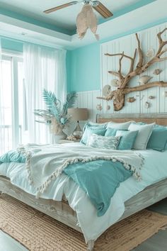 a bedroom with blue walls and white bedding in the center is decorated with driftwood pieces