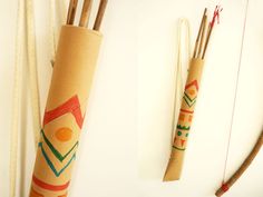 an arrow and some sticks on a white surface with other items in the back ground