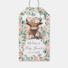 a tag with an image of a baby cow and flowers on it's side