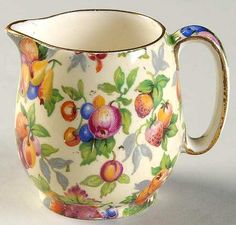 a white pitcher with colorful fruit designs on it