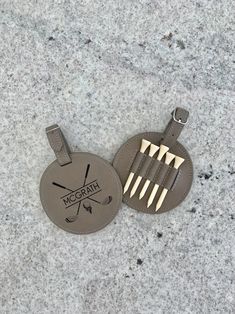 a pair of golf club and tees shaped luggage tags on a gray granite surface