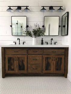 a bathroom with two sinks and three mirrors