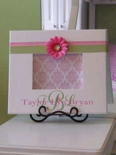 a white box with a pink flower on top and a name tag attached to it