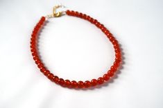 "Carnelian is a lovely semi-translucent stone in a rich orangey red color. It is highly polished for a beautiful shining quality. The stones themselves are a larger size- about 8mm around- so this is a necklace that will make a nice statement. The necklace is 15\" long with a 2\" extender chain, or it can be finished with two rings in the 18th Century style. This allows you to run a ribbon of your choice through the rings and tie it tightly on the neck, like a choker, or loose so it hangs down l Red Carnelian Beads For Gift, Red Carnelian Beads For Gifts, Handmade Red Carnelian Beaded Necklaces, Spiritual Red Carnelian Beads, Red Carnelian Spiritual Beads, Red Carnelian Hand-strung Beaded Necklaces, Red Carnelian Beaded Necklace Hand-strung, Hand-strung Red Carnelian Beaded Necklaces, Red Polished Carnelian Beads