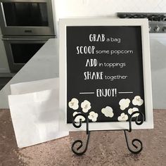 a black and white chalkboard sign on a kitchen counter with an oven in the background