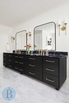 a bathroom with two sinks, mirrors and lights on the wall next to each other