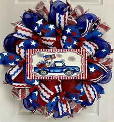 a red, white and blue wreath with an old car painted on the front door