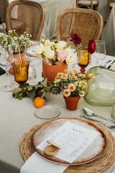 the table is set with flowers and place settings