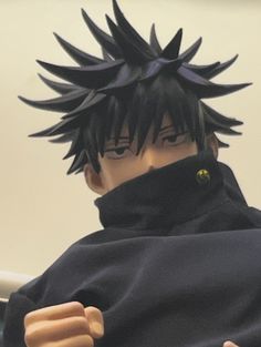 an action figure with black hair wearing a hoodie