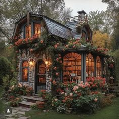 a small house with lots of flowers growing on it