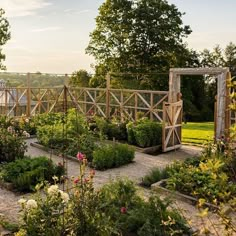 a garden with lots of flowers and plants growing in it's center, surrounded by greenery