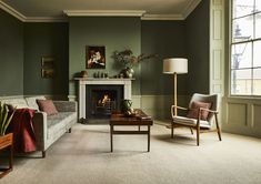 a living room filled with furniture and a fire place next to a window in front of a fireplace