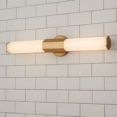 a close up of a light fixture on a brick wall with white bricks in the background