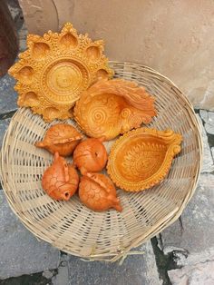 decorative wooden items displayed in basket on stone flooring area with brick wall behind them