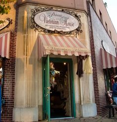 a store front with awnings and people walking by