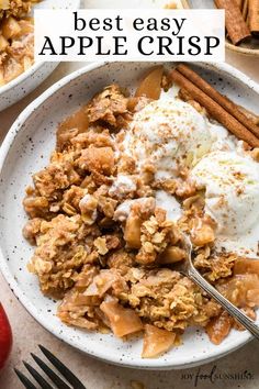 an apple crisp in a white bowl with cinnamon sticks and ice cream on the side