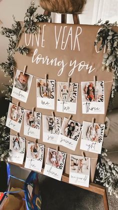 a sign that says one year old loving you with pictures on it and photos pinned to the board