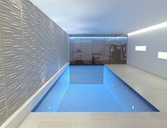 an indoor swimming pool in the middle of a room with tile flooring and walls