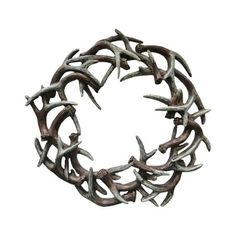 a circular sculpture made out of antlers on a white background