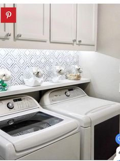 a white washer and dryer sitting next to each other in a room with cabinets