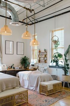 two beds in a room with hanging lights and plants on the wall next to them