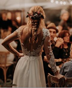 the back of a woman's dress with flowers in her hair at a wedding