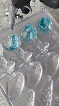 an ice tray with blue and white icing in it next to a driller